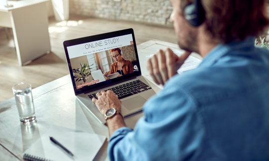 Unrecognizable man online study while using lap