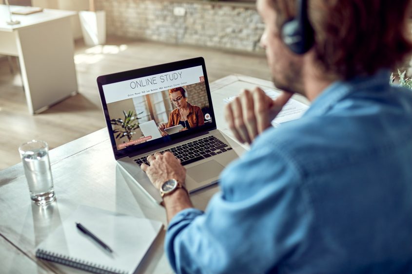 Unrecognizable man online study while using lap
